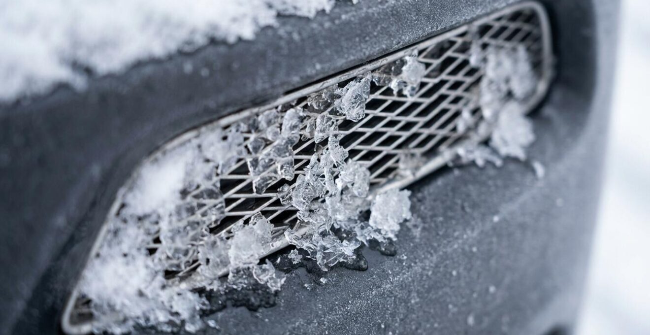 Gros plan sur un capteur radar de pare-chocs recouvert de neige et de glace