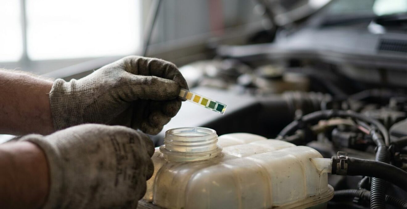 Personne effectuant un test de pH sur le liquide de refroidissement avec des bandelettes colorées